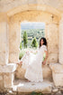 Boho-Kleid aus Baumwolle in Off-White mit goldenen Details – Model trägt das Martinique Kleid im mediterranen Setting