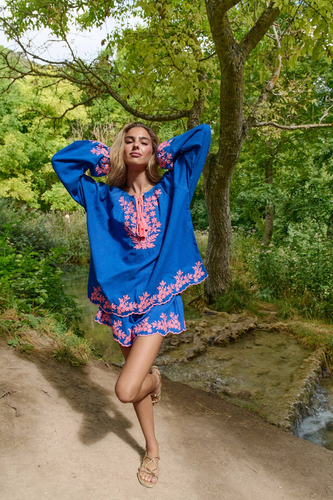 Model trägt das Guadalupe Azul Set – Boho-Zweiteiler aus Baumwolle mit pinker Stickerei in natürlicher Kulisse