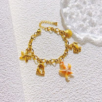 Charm-Armband mit Meeresmotiven wie Seestern, Muschel, Krabbe und Delfinen, goldfarben, Edelstahl 18K vergoldet, maritimer Schmuck für Damen