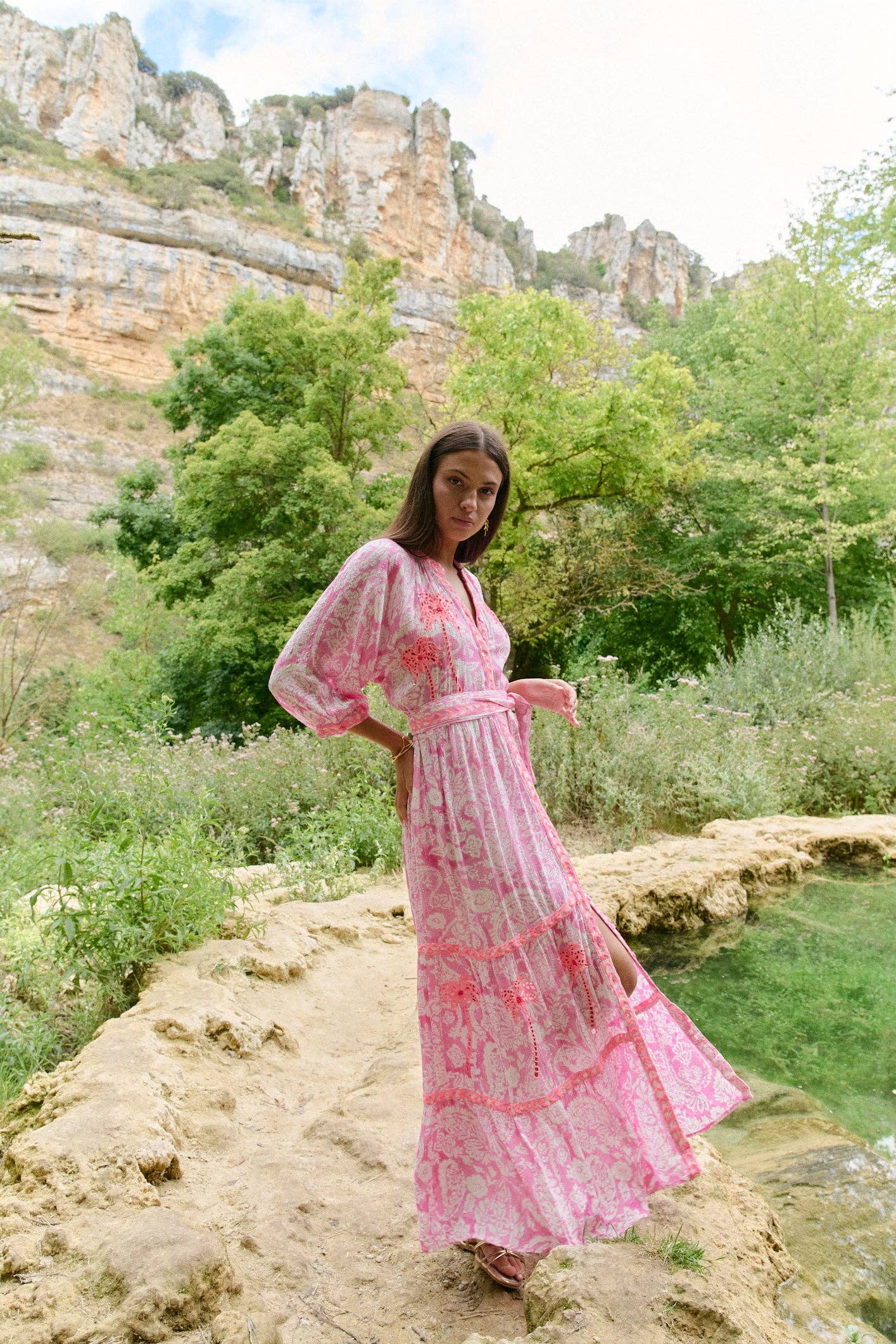 Model in Seitenansicht des Sahara Rose Maxikleids mit fließendem Rockteil