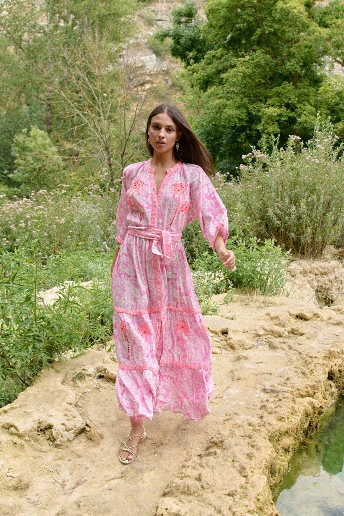 Model trägt Sahara Rose Maxikleid in floraler Landschaft – Vorderansicht in Bewegung