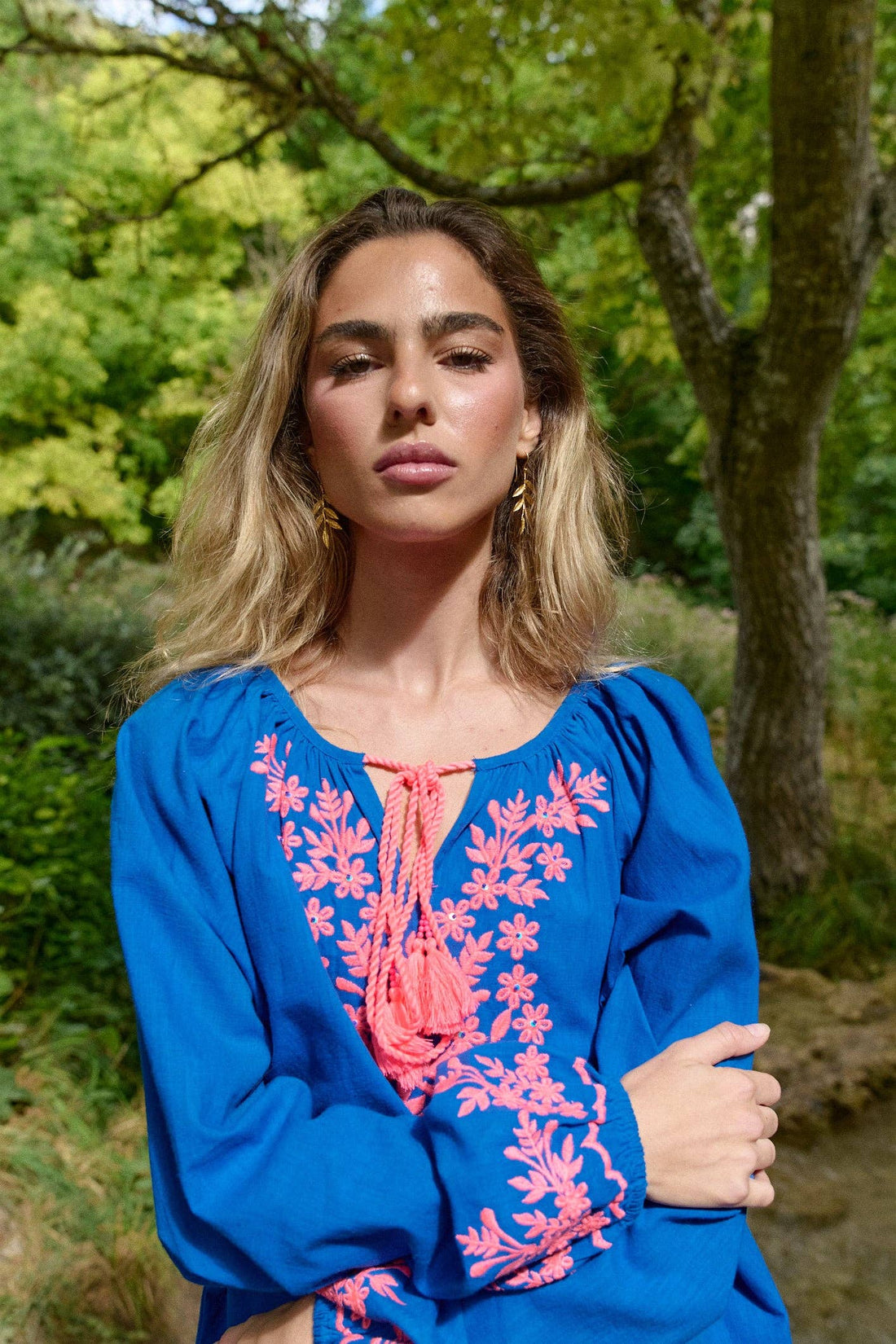 Detailansicht der Stickerei der Guadalupe Azul Bluse aus Baumwolle in Royalblau mit pinkem Muster